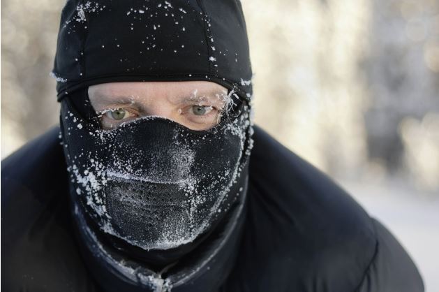 A man wearing a face mask in the snow.