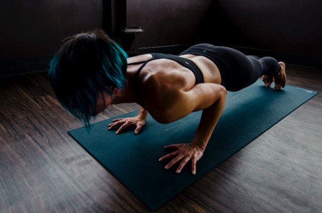 A woman doing a plank on a yoga mat.