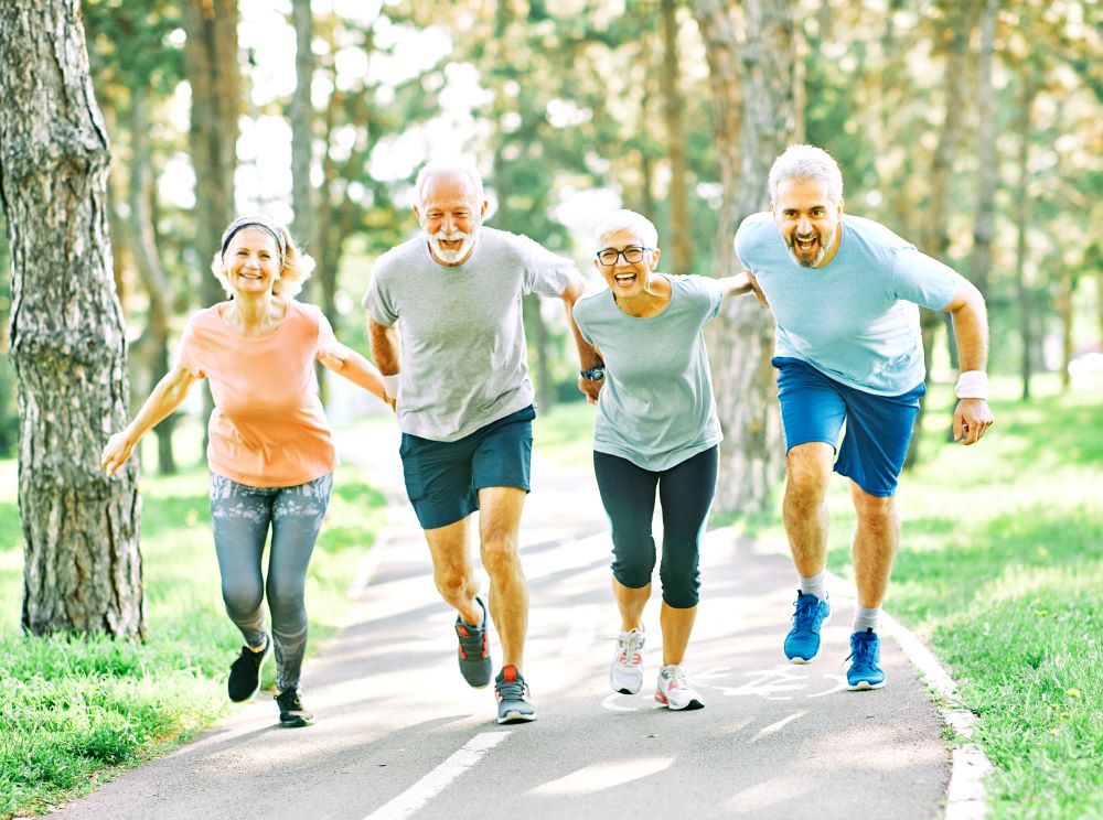 A group of older people running in a park.