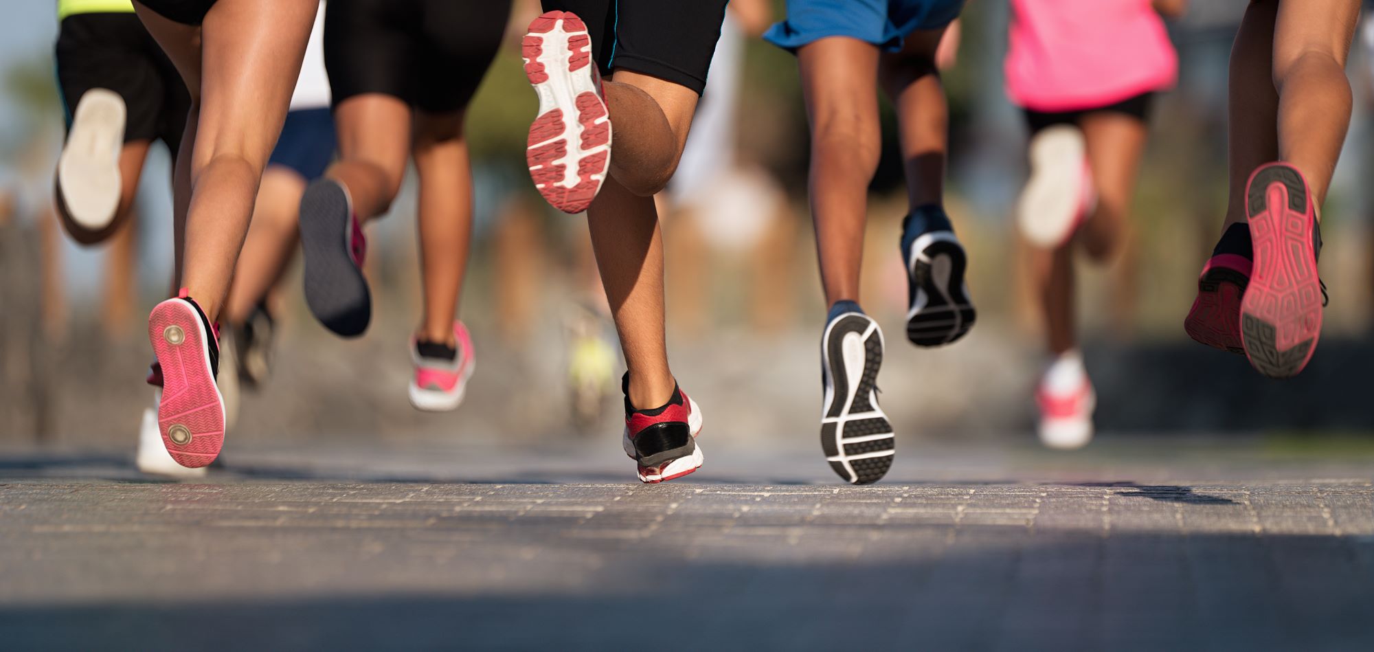 A group of people running on a sidewalk.