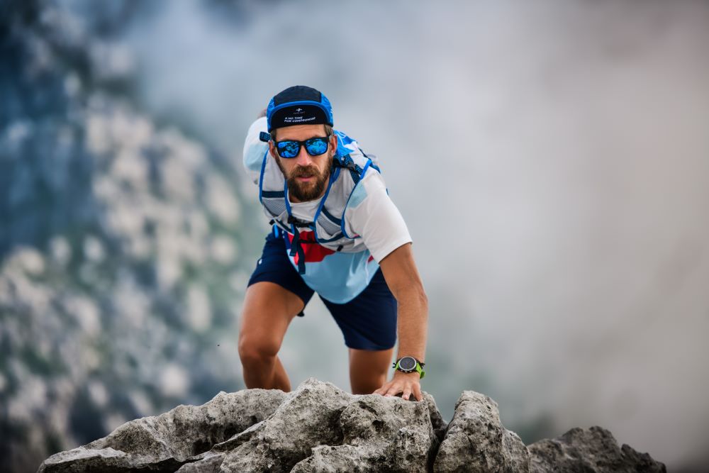 A man is climbing a rocky mountain.