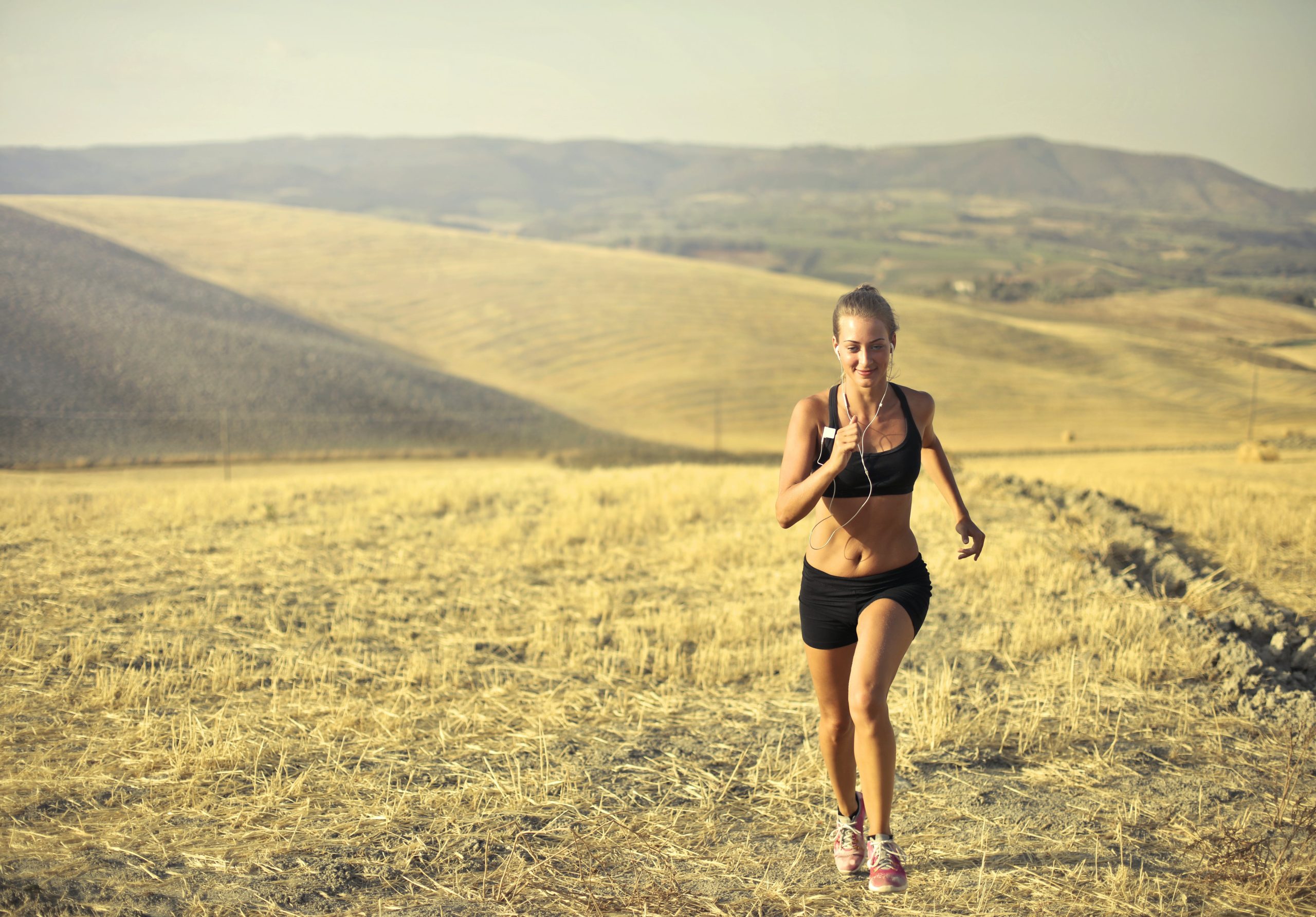 A woman jogging in a field in tuscany.