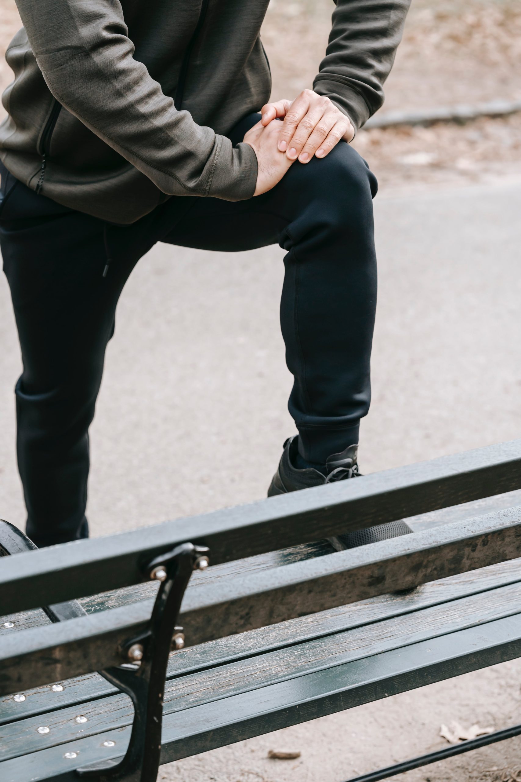 A man sitting on a bench in a park.