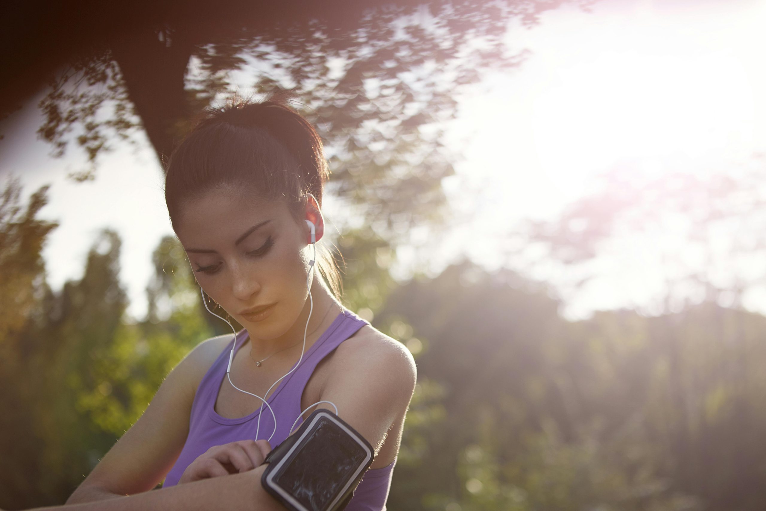 A woman is listening to her earphones while running.