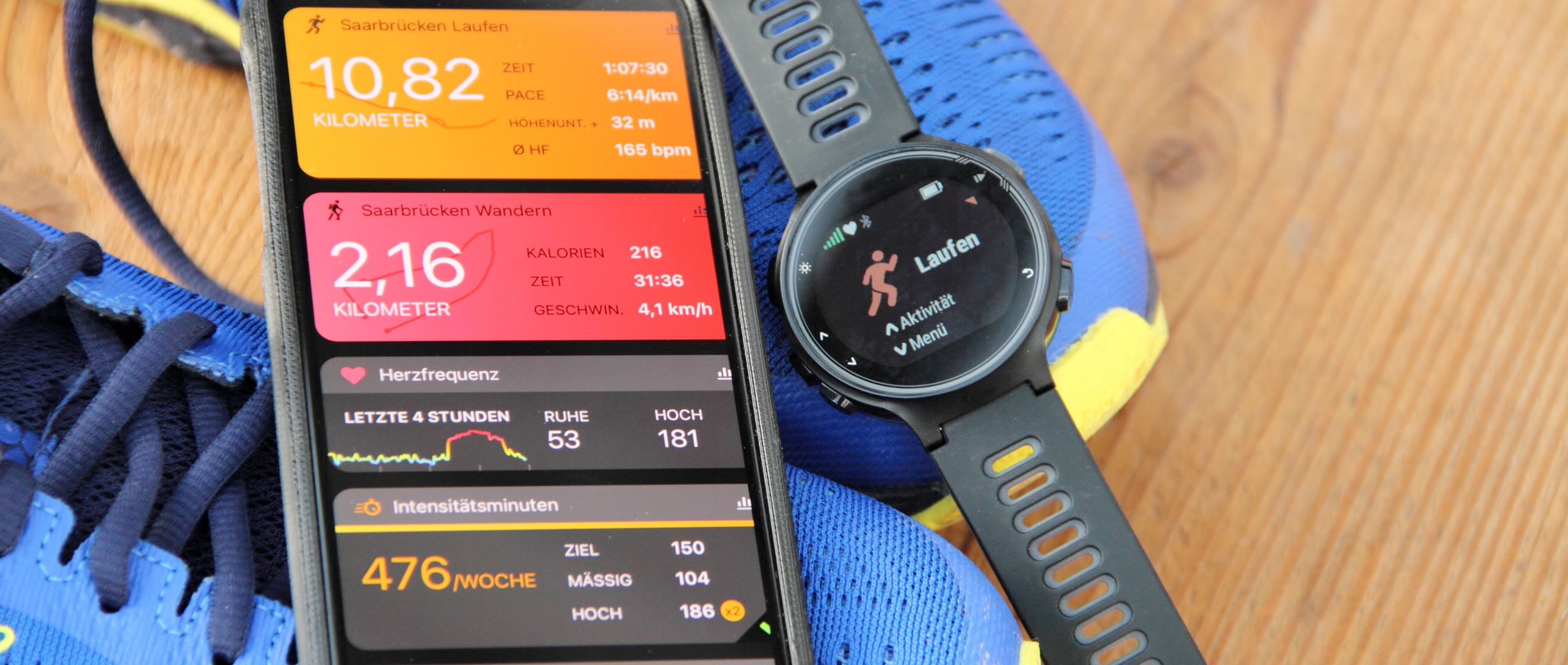 A smart watch and a pair of running shoes next to each other.