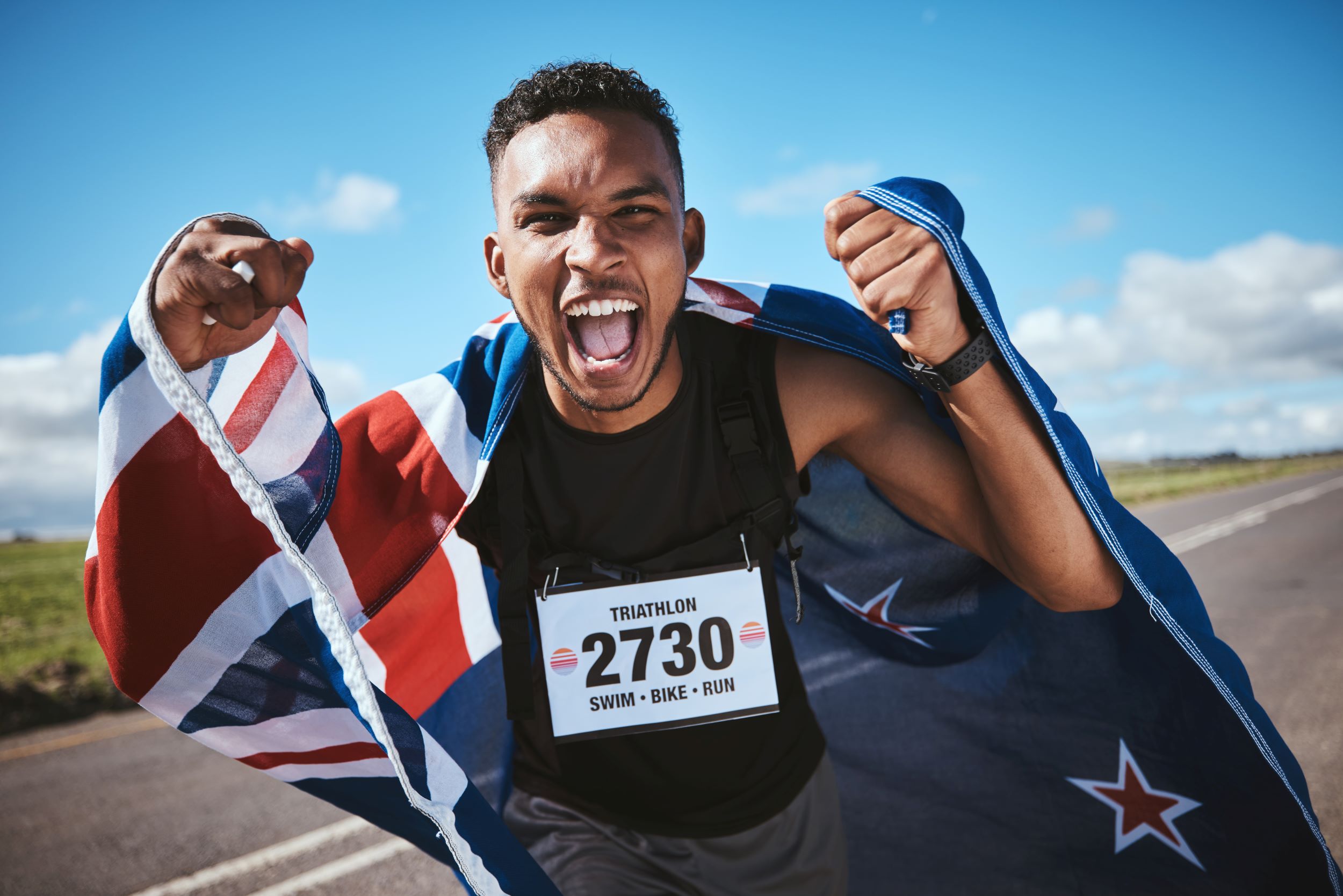 A man running with a new zealand flag.