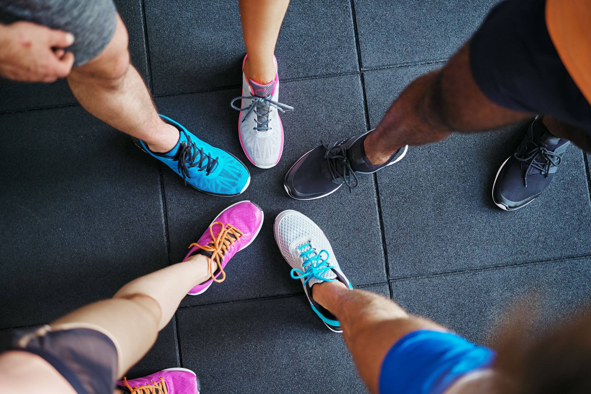 A group of people standing in a circle with their shoes on.