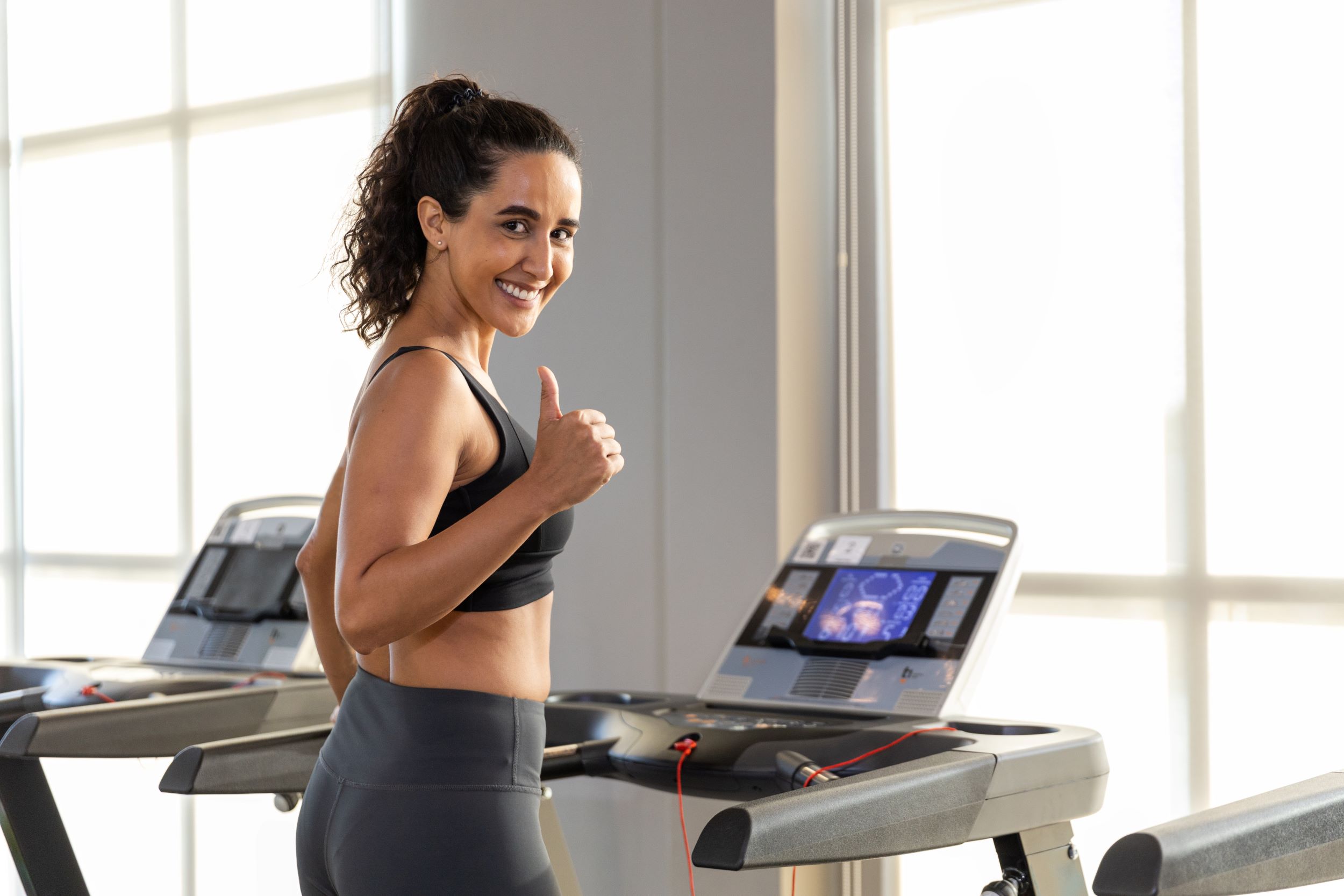 A woman standing on a treadmill.