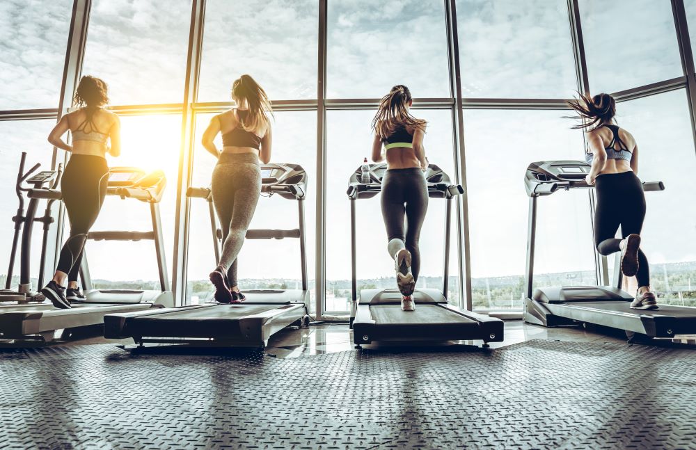 Women running on treadmills in a gym.