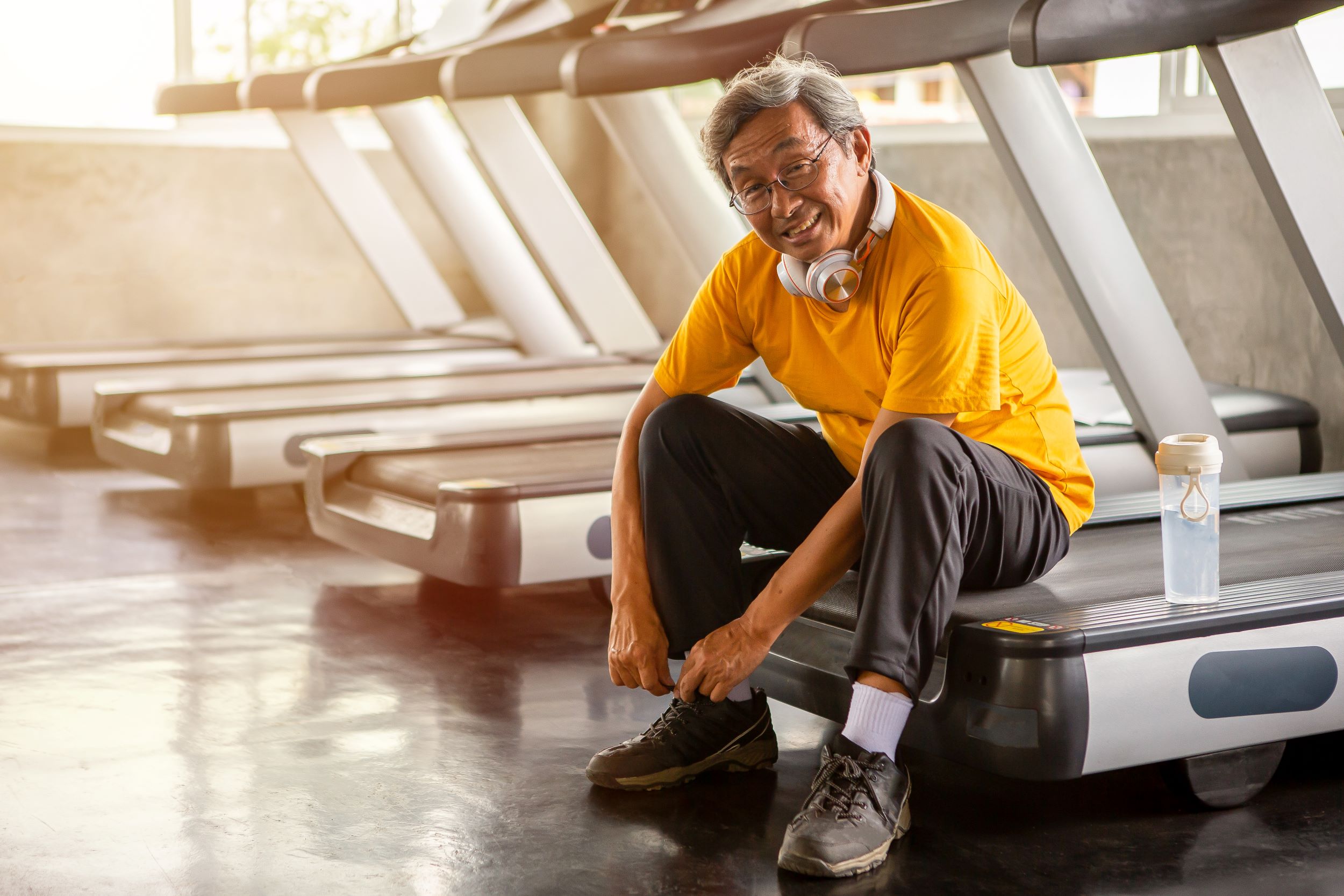 A man sitting on treadmills.